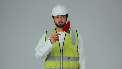 الحب والانتماء للوطن، الاحتفال بالأعياد والمناسبات الوطنية، ذكرى استقلال الإمارات 1971، هوية اليوم الوطني الاماراتي 2 ديسمبر، بورتريه لمهندس عربي خليجي إماراتي يرتدي الكندورة والخوذة وسترة الحماية يحمل علم الإمارات بتعابير المحبة والفخر، خلفية بيضاء