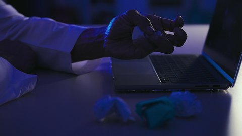 الاخفاق في الكتابة والتدوين، الفشل في العمل، تصوير مقرب ليد رجل عربي خليجي سعودي امامه الحاسب المحمول وبجانبه مجموعة من الاوراق المجعدة ، البحث عن افكار وخطط ، محاولة ايجاد حلول لتاليف قصة