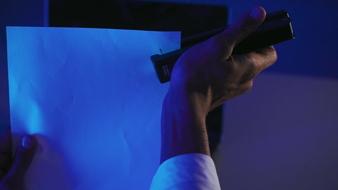 متابعة الخطط والمشاريع،  قراءة الملاحظات والمعلومات، ترتيب وتنظيم البيانات، صورة مقربة لايدي رجل عربي خليجي اماراتي يحمل بيده الدباسة يقوم بجمع مجموعة من الاوراق الفارغة مع بعضها، شاب سعودي يدقق الوثائق الخاصة بالعمل