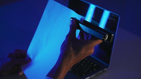 قراءة الملاحظات والمعلومات، ترتيب وتنظيم البيانات، متابعة الخطط والمشاريع، صورة مقربة لايدي رجل عربي خليجي اماراتي يحمل بيده الدباسة يقوم بجمع مجموعة من الاوراق الفارغة مع بعضها، شاب سعودي يدقق الوثائق الخاصة بالعمل