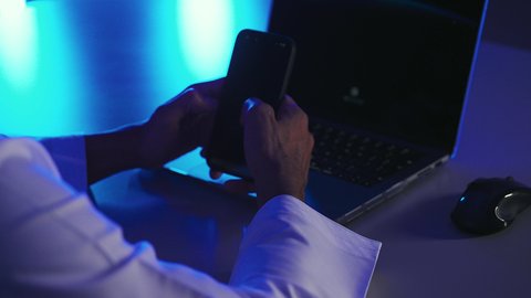 الدردشة مع الاهل و الاصدقاء، خدمات وتطبيقات الهاتف المحمول، تصفح مواقع التواصل الاجتماعي، الأجهزة التقنية الحديثة والمتطورة، تصوير مقرب ليد رجل عربي خليجي سعودي يجلس امام الحاسب المحمول يقوم باستخدام الجوال