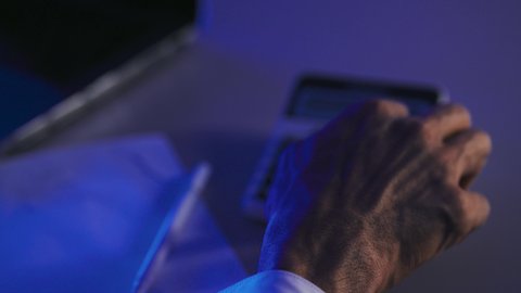 The use of modern technologies and advanced devices, facilitating work and the ability to accomplish tasks, a close-up shot of the hand of an Arab Gulf Saudi man holding a calculator to perform calculations, working in account management, accounting professions and jobs, the concept of office tools.