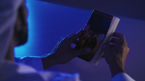 تنمية الذخيرة الثقافية، قراءة القصص والروايات الممتعة، مفهوم الثقافة والتعلم الذاتي، قضاء أوقات الفراغ بممارسة هواية المطالعة, تصوير مقرب لأيدي رجل عربي خليجي سعودي يمسك بيده الكتاب