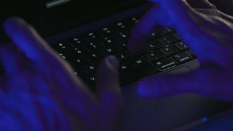 Administrative office job tasks, data entry and typing using the keyboard, integrating work with technology and tech, possessing fast typing skills on the keyboard, close-up shot of the hands of a Gulf Arab Saudi man working on a laptop.