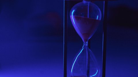 استخدام الساعة الرملية لتحديد موعد العمل، تصوير مقرب ليد امراه عربيه خليجيه سعودية تقوم بانجاز المهام بدقة وكفاءة والوقت المناسب، ادارة الجدول الزمني، مفهوم تنظيم الوقت، الكتابة على لوحة مفاتيح الحاسب المحمول