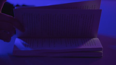 Reading enjoyable stories and novels, the concept of culture and self-learning, spending free time practicing the hobby of reading, a close-up shot of the hands of a Saudi Gulf Arab woman holding a book, developing cultural knowledge.