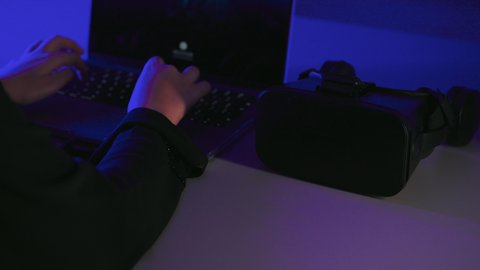 النقرعلى لوحة المفاتيح، استخدام الأجهزة التكنولوجية والتقنيات الحديثة, محاكاة العالم الخيالي, تصوير  مقرب لايدي امرأة عربية خليجية سعودية  تقوم بإنجاز العمل على جهاز الحاسوب المحمول وبجانبها نظارة الفي ار