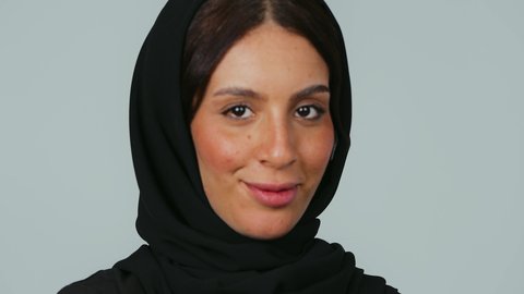 تمكين الرؤية بشكل أفضل، تصحيح النظر وطب العيون، مفهوم العدسات اللاصقة الطبية التجميلية ، بورتريه مقرب لامراة عربية خليجية سعودية محجبة تمسك بيديها العدسات التجميلية، خلفية رمادي