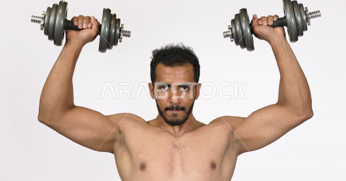 Portrait of a Saudi Arabian Gulf Arab man carrying iron weights in his