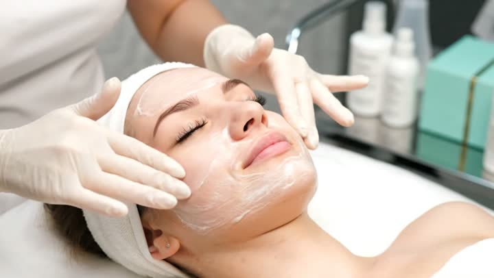 امرأة عربية خليجية سعودية في صالون تجميلي نسائي، تضع كريم الترطيب ، مفهوم العناية والإهتمام بنضارة الوجه، تقشير وتفتيح البشرة، إستخدام مكونات تجميلية