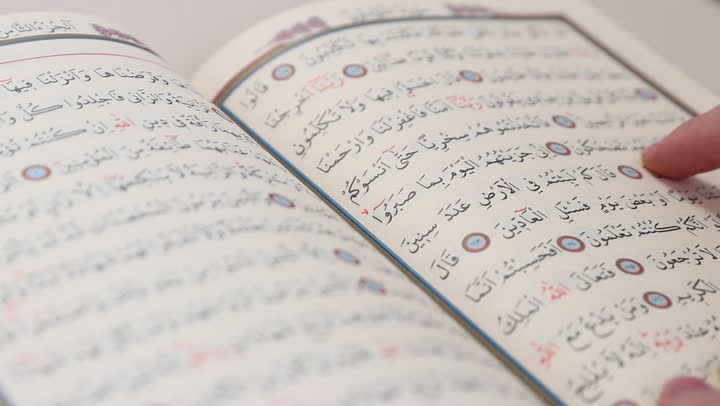 الاجتهاد في العبادة، تلاوة وقراءة القرآن الكريم وتدبر معانيه، تصوير مقرب لرجل عربي خليجي سعودي يحمل بيده المصحف الشريف، الإكثار من ذكر الله تعالى، التقرب الى الله في شهر رمضان، الشعور بالخشوع والطمأنينة