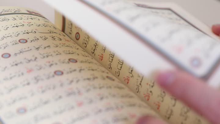 Diligence in worship, recitation and reading of the Holy Quran and reflecting on its meanings, a close-up image of a Saudi Arabian Gulf man holding the Holy Quran in his hand, increasing the remembrance of Allah Almighty, drawing closer to Allah during the month of Ramadan, feeling humility and tranquility.