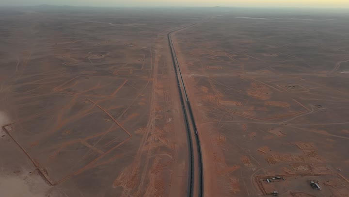 Desert roads in sandy areas, the terrain of peaks and highlands, an asphalt travel road during the day, rock formations and natural landscapes.