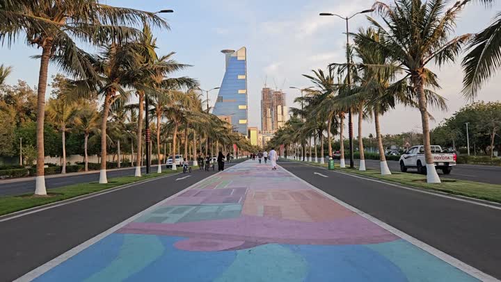 The cultivation of palm trees in tourist cities, the progress and urban development of towers and skyscrapers, famous places and tourist attractions, footage of people walking and car traffic on the new Corniche of Jeddah city in the Kingdom of Saudi Arabia.