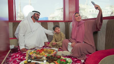 اجواء عائلية ممتعة ، مطاعم للمأكولات الشرقية ، فنون الطهي ووصفات طعام المطبخ الاماراتي،   منسف من الأرز الأبيض مع الدجاج المحمر والتوابل المزين بالخضراوات في احدى المطاعم الاماراتية ، عائلة عربية خليجية اماراتية تقوم بتناول اطباق شعبية شهية