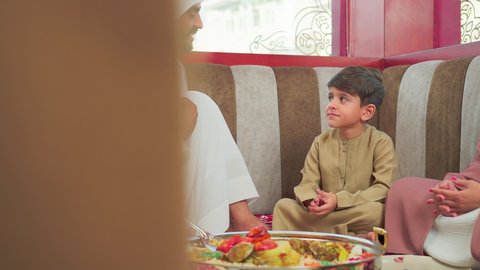 حوارات و نقاشات عائلية  ، مطاعم للمأكولات الشرقية ، فنون الطهي ووصفات طعام المطبخ الاماراتي،   منسف من الأرز الأبيض مع الدجاج المحمر والتوابل المزين بالخضراوات في احدى المطاعم الاماراتية ، عائلة عربية خليجية اماراتية تقوم بتناول اطباق شعبية شهية