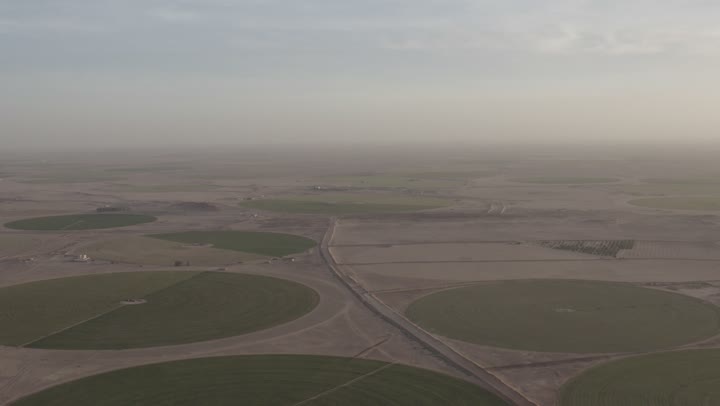 Attention to green spaces, trees, and plants in famous cities and tourist areas, aerial drone photography of the lands and farms of the Kingdom of Saudi Arabia, circular agricultural fields, enjoying the serene natural views during the day, agricultural crops and local national products.