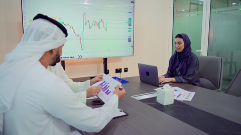 تطوير المشاريع و الاستثمارات, دمج الأجهزة التقنية الحديثة بالأعمال المكتبية، تطوير المشاريع و الاستثمارات، إدارة و تقسيم المهام، شرح و تحليل الرسوم البيانية, فريق عمل عربي خليجي اماراتي يقوم بإجراء اجتماع عمل داخل غرفة الاجتماعات في مقر الشركة