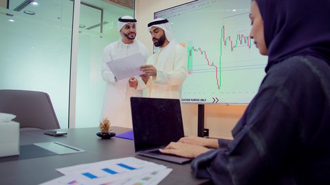 تبادل الخبرات والأفكار لتحقيق أهداف الشركة، دمج الأجهزة التقنية الحديثة بالأعمال المكتبية، تطوير المشاريع و الاستثمارات، إدارة و تقسيم المهام، شرح و تحليل الرسوم البيانية, فريق عمل عربي خليجي اماراتي يقوم بإجراء اجتماع عمل داخل غرفة الاجتماعات في مقر الشركة