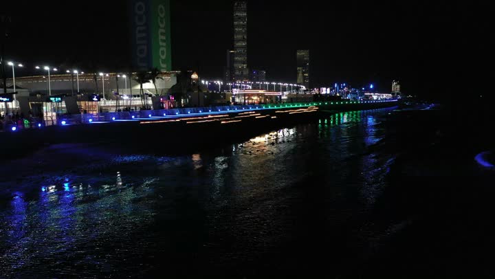 الأمواج المتلاطمة في البحر الأحمر، اماكن ومعالم سياحة، الفن الهندسي المتطور للأبراج وناطحات السحاب، نشاط رياضي ترفيهي شبابي، رياضة السيارات على ساحل جدة، تصوير درون لمسار حلبة كورنيش جدة في المملكة العربية السعودية المضاءة في وقت الليل، مضمار سباقات للفورمولا 1