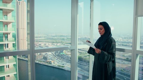 متابعة مخطط الرسم البياني، تدقيق وتحليل بيانات المشروع، امراه عربيه خليجيه اماراتيه تقوم بتحليل البيانات ، دراسة مشاريع جديدة، صعود وهبوط البورصة، النمو الاقتصادي والاستثمار المالي، سيدة سعودية ترتدي الحجاب والعباءة، مهن ووظائف مكتبية