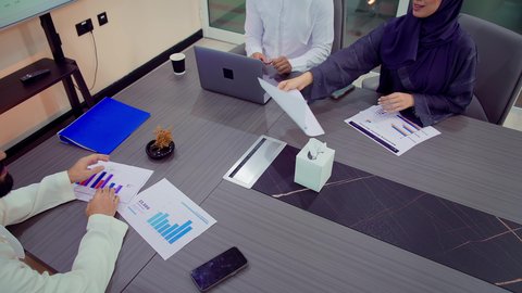 تبادل الخبرات والأفكار لتحقيق أهداف الشركة، شرح و تحليل الرسوم البيانية, تصويرمقرب لفريق عمل عربي خليجي اماراتي يقوم بإجراء اجتماع عمل داخل غرفة الاجتماعات في مقر الشركة، تطوير المشاريع و الاستثمارات، تسليم المهام والمشاريع بالوقت المحدد