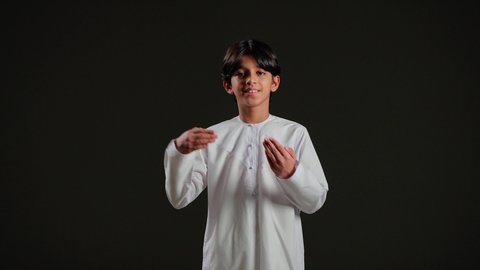 الإشارة إلى عنصر ما, التوضيح والدلالة لمكان محدد, بورتريه لولد عربي خليجي سعودي يرتدي الثوب الابيض يشير بيدية على الجانب، تحديد موقع شيء معين, خلفية سوداء