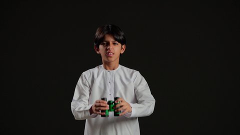 حب المغامرة والاستكشاف، رؤية الاشياء البعيدة عبر المنظار، بورتريه لولد عربي خليجي سعودي يرتدي الثوب الابيض ينظر من خلال المنظور بإيماءات وجه مختلفة, التخطيط المستقبلي للأهداف والطموحات، خلفية سوداء