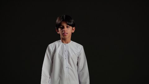 رؤية الاشياء البعيدة عبر المنظار، حب المغامرة والاستكشاف، بورتريه لولد عربي خليجي سعودي يرتدي الثوب الابيض ينظر من خلال المنظور بإيماءات وجه مختلفة, التخطيط المستقبلي للأهداف والطموحات، خلفية سوداء