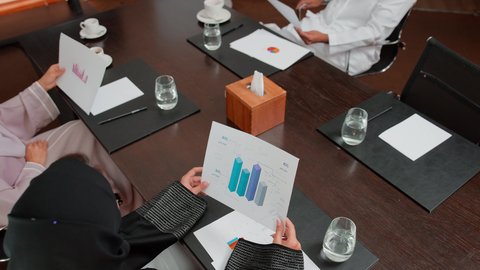 The concept of economic growth and financial investment, an Arab Gulf Emirati woman analyzing data on a laptop, studying new projects, following a chart, using modern technology and techniques, reviewing work reports
