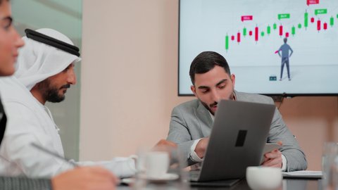 Studying new projects, following up on the flowchart, using modern technology and techniques, reviewing work reports, the concept of economic growth and financial investment, Arab Gulf and Emirati business friends analyzing data on a laptop