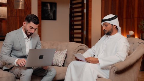 مفهوم النمو الاقتصادي والاستثمار المالي، متابعة مخطط الرسم البياني، تدقيق وتحليل بيانات المشروع،  استخدام التكنولوجيا والتقنيات الحديثة فى العمل ، دراسة مشاريع جديدة، زميلان عمل عربيان خليجيان اماراتيان يقومان بتحليل البيانات على الحاسوب المحمول