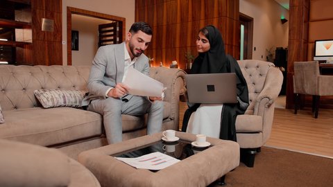 دراسة مشاريع جديدة، زميلان عمل عربيان خليجيان اماراتيان يقومان بتحليل البيانات على الحاسوب المحمول، متابعة مخطط الرسم البياني، تدقيق وتحليل بيانات المشروع، مفهوم النمو الاقتصادي والاستثمار المالي