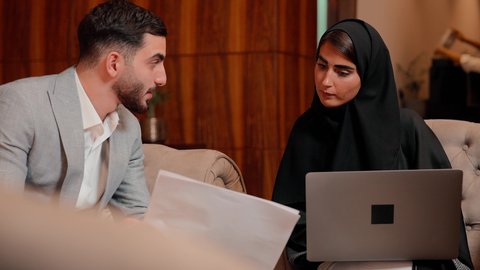 زميلان عمل عربيان خليجيان اماراتيان يقومان بتحليل البيانات على الحاسوب المحمول، متابعة مخطط الرسم البياني، تدقيق وتحليل بيانات المشروع، دراسة مشاريع جديدة، مفهوم النمو الاقتصادي والاستثمار المالي