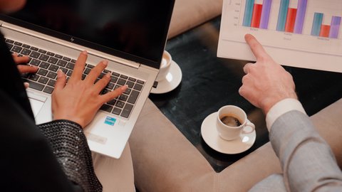 استخدام التقنيات الحديثة فى العمل ، زميلان عمل عربيان خليجيان اماراتيان يقومان بتحليل البيانات على الحاسوب المحمول، متابعة مخطط الرسم البياني، تدقيق وتحليل بيانات المشروع، دراسة مشاريع جديدة، مفهوم النمو الاقتصادي والاستثمار المالي