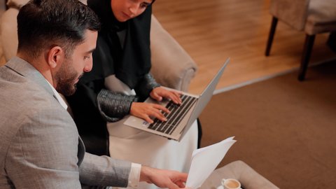 دراسة مشاريع جديدة، زميلان عمل عربيان خليجيان اماراتيان يقومان بتحليل البيانات على الحاسوب المحمول، متابعة مخطط الرسم البياني، تدقيق وتحليل بيانات المشروع، مفهوم النمو الاقتصادي والاستثمار المالي