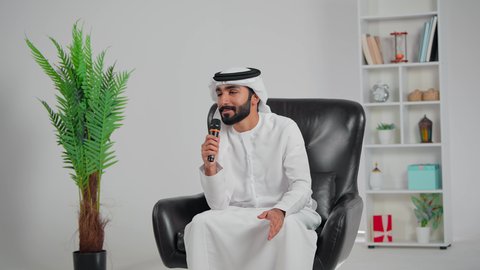 إلقاء المحاضرات وإقامة الندوات، الدورات التدريبية و ورشات العمل، تسجيل المقاطع الصوتية والغنائية، رجل عربي خليجي اماراتي يرتدي الكندورة و الغتره يجلس على كرسي يحمل بيده مكبر الصوت