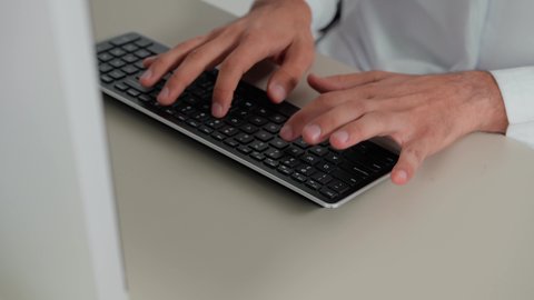 Keyboard tapping, text content creation, data entry concept, close-up of an Emirati Gulf Arab man's hand using a computer, typing on a computer, integrating modern technology into practical life, office management professions and jobs