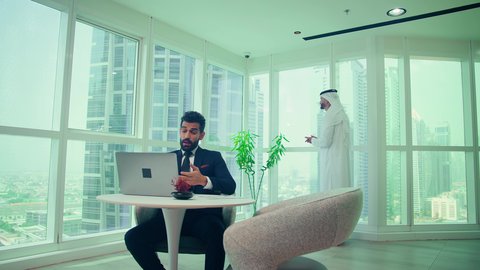 دراسة مشاريع جديدة، إستخدام تقنيات حديثة،  رجل اماراتي يرتدي البدلة الرسمية يقوم باجراء مكالمة فيديو عبر جهاز الحاسوب المحمول، مفهوم إدارة الأعمال، تدقيق وتحليل بيانات المشروع، النمو الاقتصادي والاستثمار المالي ، إنجاز المهام من خلال اللابتوب ، شاب اماراتي يرتدي الكندورة والغترة يقوم باجراء مكالمة هاتفية عبر الجوال