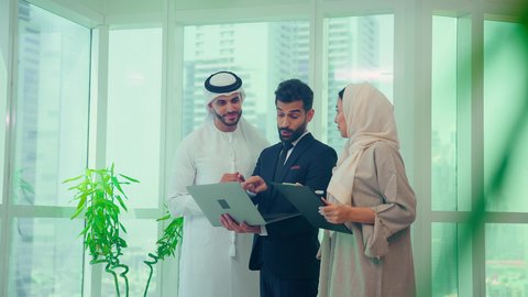 اجتماع زملاء عمل عربيين خليجيين اماراتيين مع رجل يرتدي البدلة الرسمية لتحليل وتدقيق المشروع عبر جهاز الحاسوب المحمول،  النمو الاقتصادي والاستثمار المالي، دراسة مشاريع جديدة، إستخدام تقنيات حديثة، مفهوم إدارة الأعمال، إنجاز المهام من خلال اللابتوب