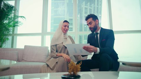 تحليل وتخطيط المشاريع، اتفاقية عمل لمشروع جديد، امراه عربيه خليجيه اماراتيه ترتدي العباءة والحجاب تتناقش مع عميل يرتدي البدلة الرسمية، تطوير العمل وحل المشكلات، الوحدة والعمل الجماعي، تحقيق اهداف الشركه