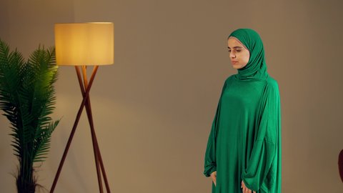 مفهوم العبادة والتقرب إلى الله, الاجتهاد في الطاعات والأدعية والأذكار,امرأة عربية خليجية إماراتية ترتدي العباءة والحجاب ترفع يديها للأعلى بتعابير الدعاء, شابة سعودية تصلي بايماءات الخشوع والطمأنينة