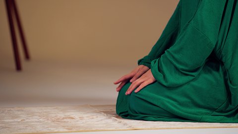سيدة سعودية تسجد بايماءات الخشوع والطمأنينة، مفهوم أركان الاسلام والأيمان، التقرب الى الله ، الحفاظ على إقامة الصلوات الخمس بوقتها، الإجتهاد في العبادة، امراه عربيه خليجيه اماراتيه ترتدي العباءه والحجاب تجلس على سجادة الصلاة تقوم بأداء فريضة الصلاة
