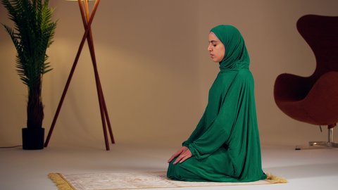 الإجتهاد في العبادة، امراه عربيه خليجيه اماراتيه ترتدي العباءه والحجاب تجلس على سجادة الصلاة تقوم بأداء فريضة الصلاة، سيدة سعودية تسجد بايماءات الخشوع والطمأنينة، مفهوم أركان الاسلام والأيمان، التقرب الى الله ، الحفاظ على إقامة الصلوات الخمس بوقتها