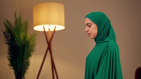 امراه عربيه خليجيه اماراتيه ترتدي العباءه والحجاب تحمل بيدها القرآن ، مفهوم التمعن بآيات وسور القران الكريم ،الاجتهاد في العبادة، قراءة كتاب الله وحفظه وتجويده، تلاوة المصحف الشريف، سيدة سعودية تقوم بذكر الله تعالي