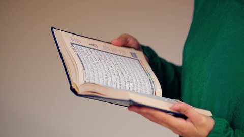 قراءة كتاب الله وحفظه وتجويده، تلاوة المصحف الشريف، مفهوم التمعن بآيات وسور القران الكريم ،الاجتهاد في العبادة،امراه عربيه خليجيه اماراتيه ترتدي العباءه والحجاب تحمل بيدها القرآن ، سيدة سعودية تقوم بذكر الله تعالي