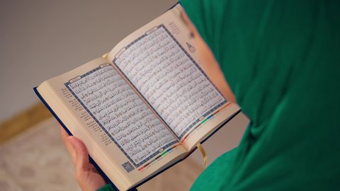 سيدة سعودية تقوم بذكر الله تعالي، مفهوم الاجتهاد في العبادة، قراءة كتاب الله وحفظه وتجويده، تلاوة المصحف الشريف، امراه عربيه خليجيه اماراتيه ترتدي العباءه والحجاب تحمل بيدها القرآن