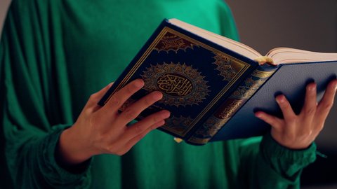 ايماءات الاستغفار والدعاء، مفهوم الاجتهاد في العبادة، قراءة كتاب الله وحفظه وتجويده، تلاوة المصحف الشريف، امراه عربيه خليجيه اماراتيه ترتدي العباءه والحجاب تحمل بيدها القرآن ، سيدة سعودية تقوم بذكر الله تعالي