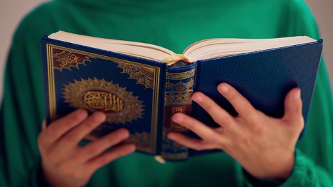 مفهوم الاجتهاد في العبادة، قراءة كتاب الله وحفظه وتجويده، تلاوة المصحف الشريف، امراه عربيه خليجيه اماراتيه ترتدي العباءه والحجاب تحمل بيدها القرآن ، سيدة سعودية تقوم بذكر الله تعالي