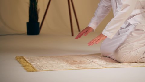 التقرب الى الله ، الحفاظ على إقامة الصلوات الخمس بوقتها، الإجتهاد في العبادة، شاب عربي خليجي اماراتي يرتدي الثوب الأبيض والطاقية يجلس على سجاده الصلاه يقوم بأداء فريضة الصلاة،الشعور بالخشوع والطمأنينة  ، مفهوم أركان الاسلام والأيمان،اجواء روحانية رمضانية